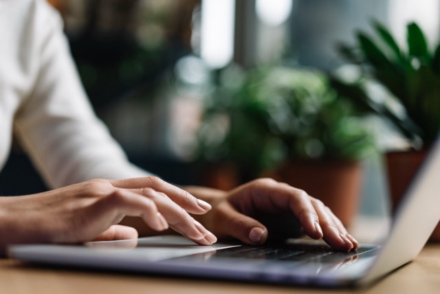 Woman typing at a computer assisting with concierge requests