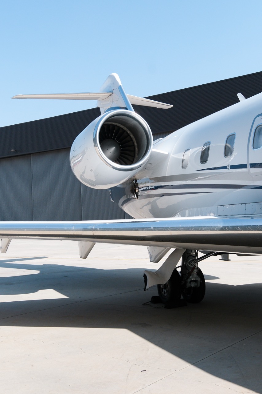 Challenger 604 heavy jet exterior parked on the tarmac with twin engines and sleek white fuselage.