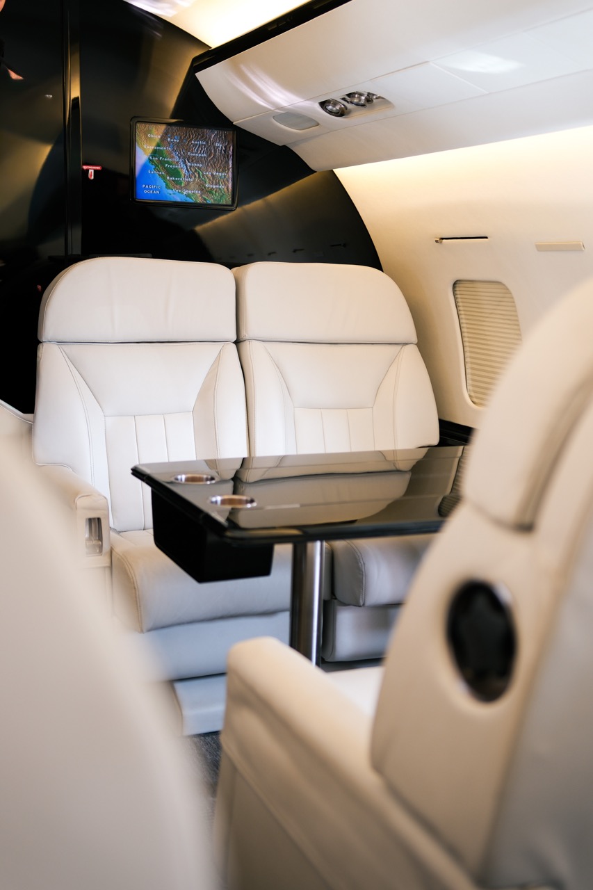 Gulfstream G200 tan cabin interior with club seating and workspace for business and long-haul executive travel.