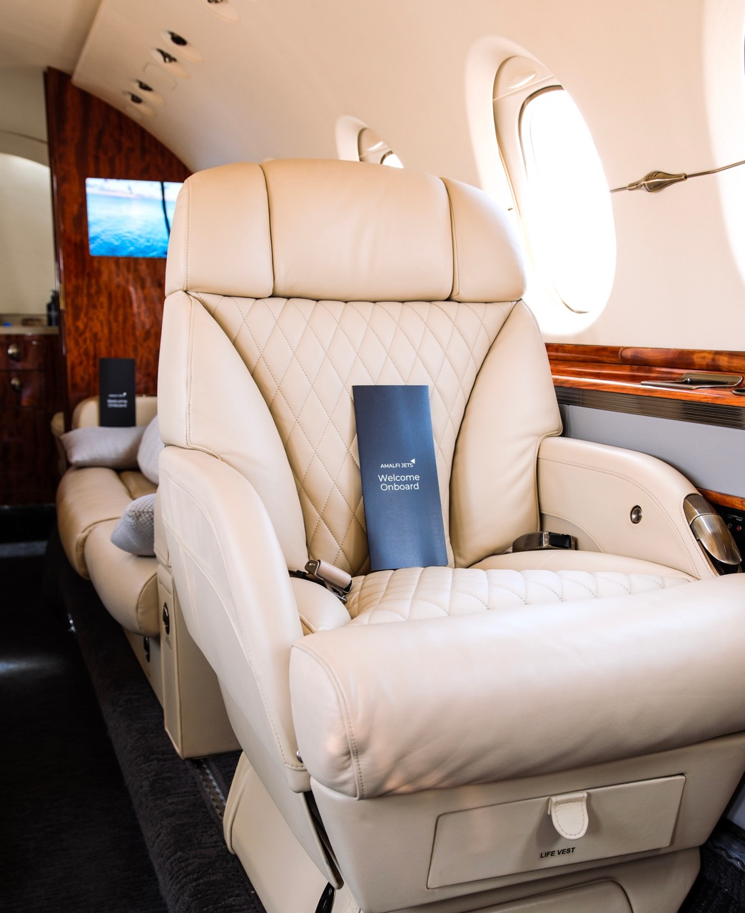 Learjet 60 cabin interior with black leather seats and polished wood paneling for midsize private travel.