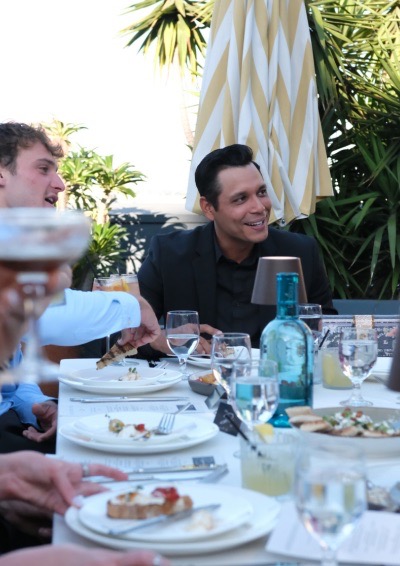 Man smiling at a table talking with guests enjoying dinner at An Evening with Amalfi.