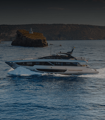 Midsize silver yacht with black windows cruising through the water.