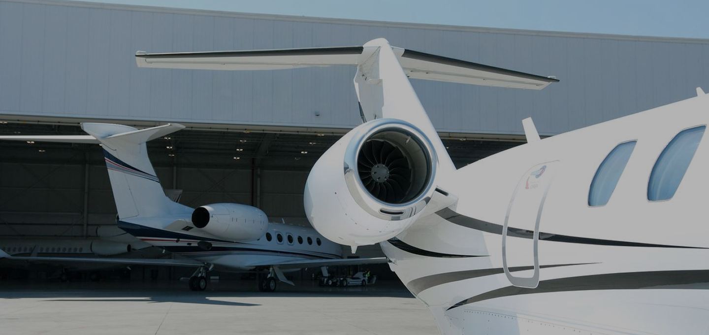 Close-up of a Cessna Citation private jet with polished engines, parked near a Gulfstream in a modern aircraft hangar.