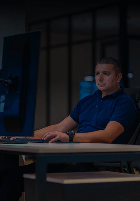Man in a blue shirt working on his computer tracking amalfi jet flights.