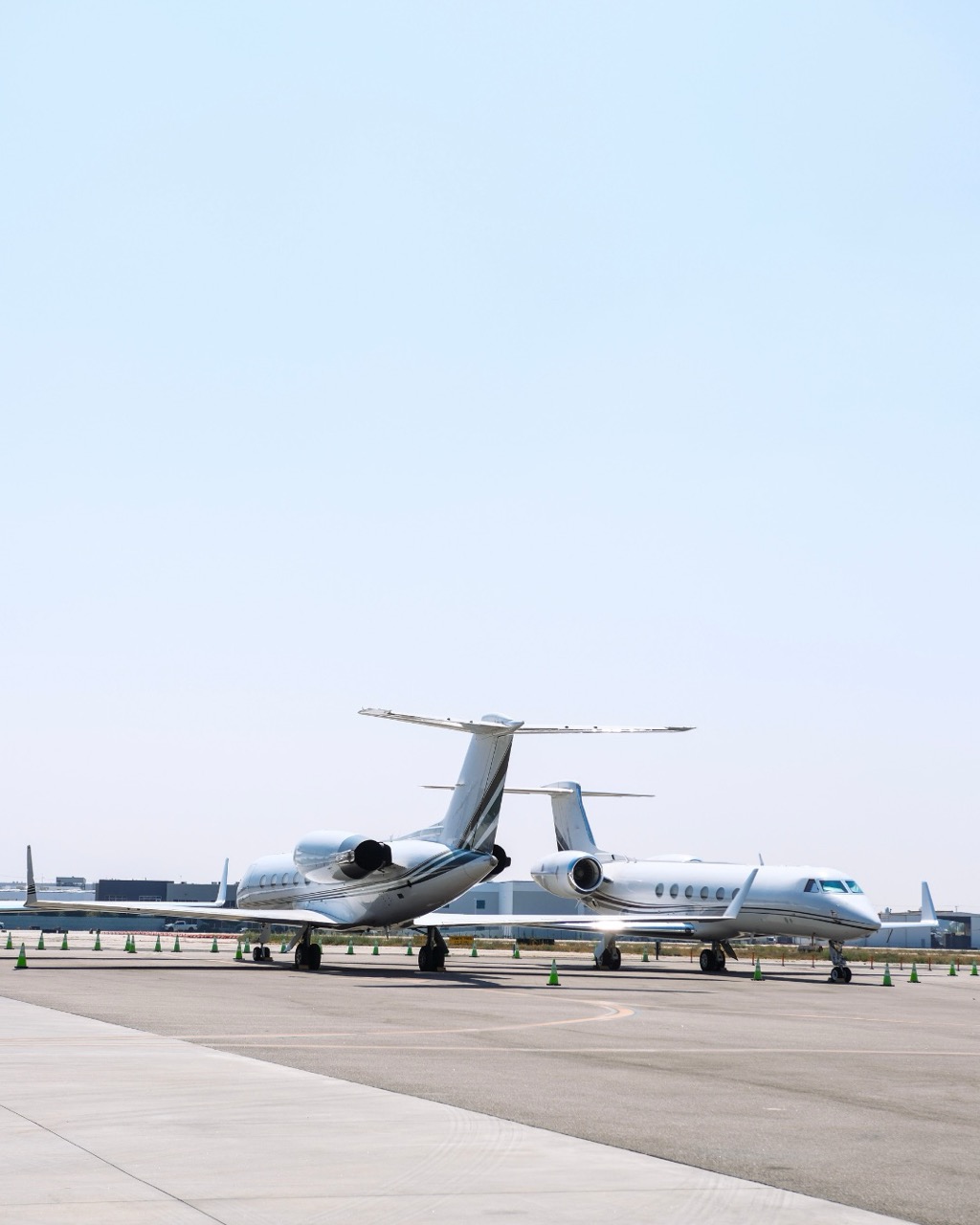 Two Gulfstream private jets, a G550 and G650, parked on the tarmac at an airport, available through Amalfi Jets charter service.